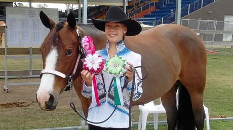 A 12-year-old Courtney Smallwood with Australian Champion horse in showmanship Hottie aka J Bar C Blazin Hot T received rosettes for winning in the showmanship competition.