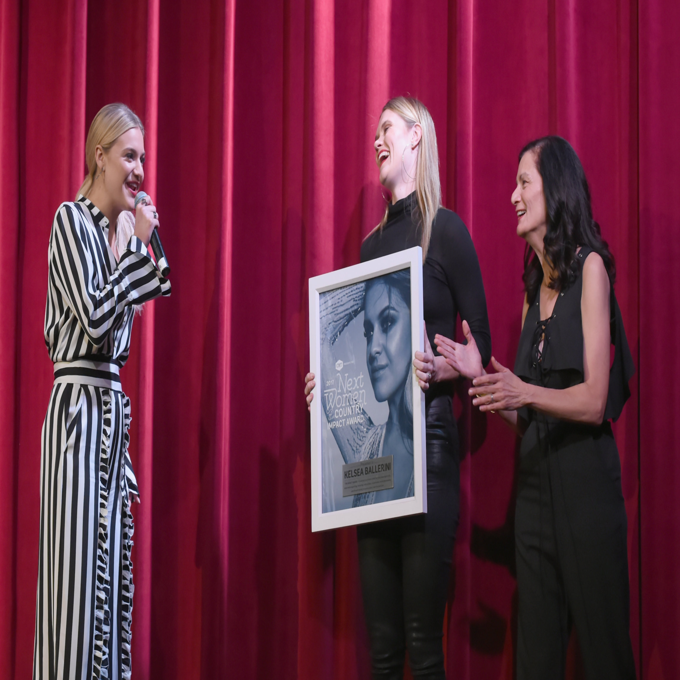 NASHVILLE, TN - NOVEMBER 07: Kelsea Ballerini is presented the Impact Award from songwriter Nicolle Galyon and Senior Vice President of Music Strategy for CMT Leslie Fram during the 2017 CMT Next Women Of Country Celebration at City Winery Nashville on November 7, 2017 in Nashville, Tennessee. (Photo by Rick Diamond/Getty Images for CMT)