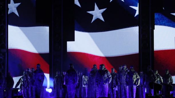 Kendrick Lamar (left, rear, in white shirt) performs a medley in front of an American flag at the 60th Annual Grammy Awards on Jan. 28, 2018.