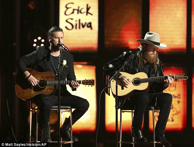 On Sunday, the singers performed a haunting version of Eric Clapton's ballad Tears in Heaven seated side by side in front of a backdrop lit up with the names of the victims. T.J. Osborne (left) and John Osborne (right) of the Brothers Osborne