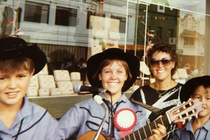 Three young buskers (including Felicity Urquhart) and a mother pose for a photo outside a jewellery store in Tamworth.