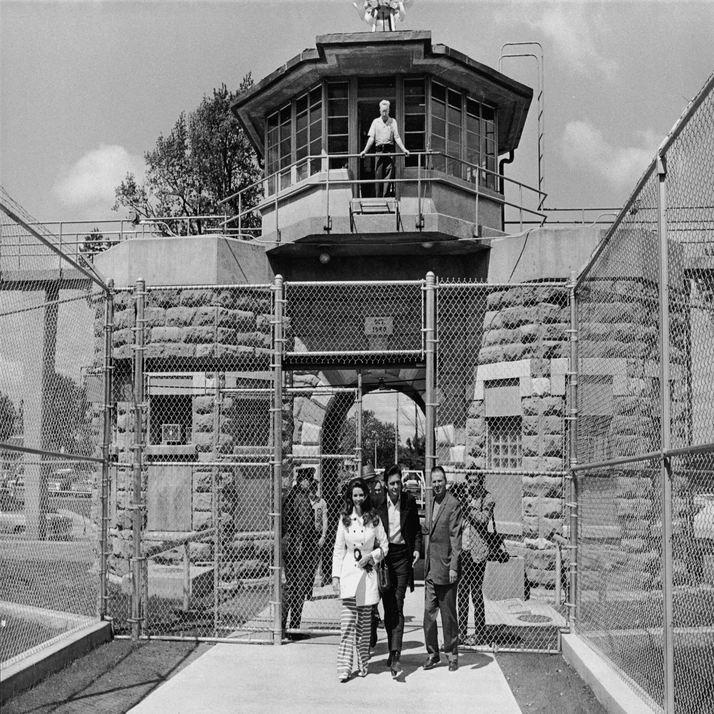 American country singer Johnny Cash (1932 - 2003) and his wife June Carter Cash (1929 - 2003) leave the front gate of Kansas State Prison, circa 1968. (Photo by Hulton Archive/Getty Images)